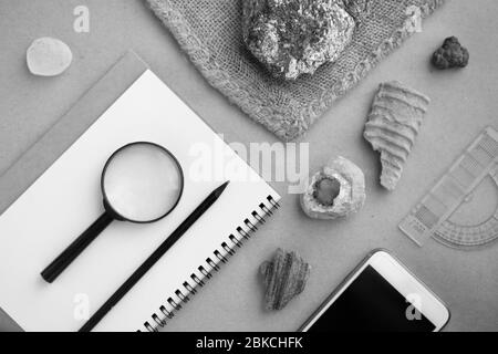 Geology rock laboratory. Stone samples, loop, notebook and mobile phome at geological laboratory. Laboratory for analysis of geological soil materials Stock Photo