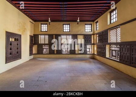 Interior wall with decorated lattice wooden windows, Mashrabiya, and sliding wooden shutters at ottoman era Amasely historic house, Rosetta City, Egypt Stock Photo