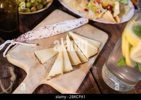 Mix of different snacks and appetizers. Spanish tapas on a wooden table. Tapas bar. Olives, sausage, cheese, jamon, nachos, canapes. Top view Stock Photo