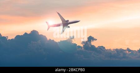 Commercial airplane, aircraft in the sky during sunset, evening sky and passenger plane Stock Photo