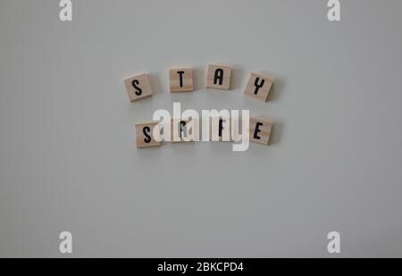 Stay Safe written in wooden letter tiles on a white background.  Concept safety, emergency, hurricane, danger, coronavirus, pandemic, protection, snow Stock Photo