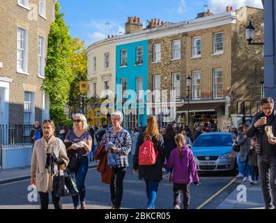 Londoners and tourists walking on the pavement and street at the south side of Portobello Road, Notting Hill, West London, England, UK Stock Photo