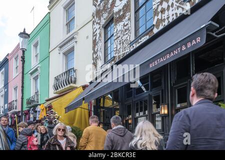 Portobello Road, crowded with people  shopping in front of Gold restaurant & bar with mural of Eye Contact on façade of building. Notting Hill, London Stock Photo