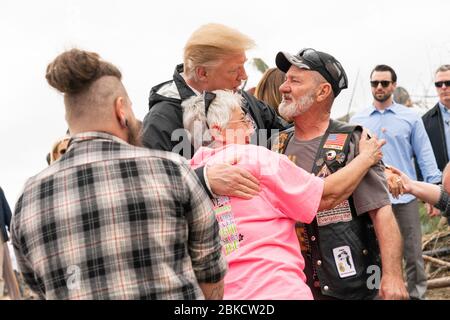 President Donald J. Trump is embraced by residents Friday, March 8, 2019, as he visits a neighborhood devastated by a tornado that touched down Sunday in Lee County, Ala. President Trump and First Lady Melania Trump Visit Alabama Stock Photo