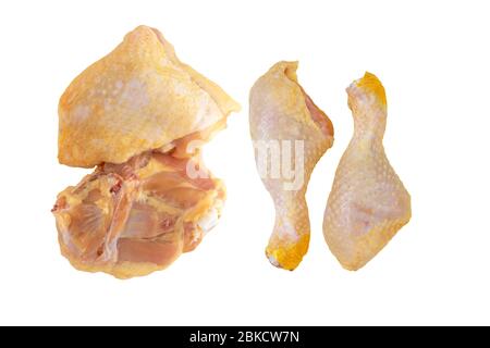 Raw yellow corn fed chicken legs and thighs isolated on white. Stock Photo