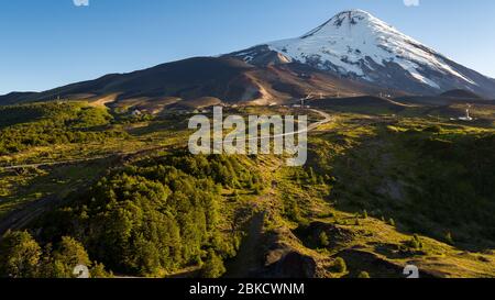 Path leading to the foot of the Osorno volcano, all green and snowless surroundings in summer season Stock Photo