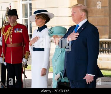 President Donald J. Trump and First Lady Melania Trump, joined by Britain’s Queen Elizabeth II, place their hands on their heart for the national anthem during a welcome ceremony at Buckingham Palace Monday, June 3, 2019, in London. President Trump and First Lady Melania Trump's Trip to the United Kingdom Stock Photo