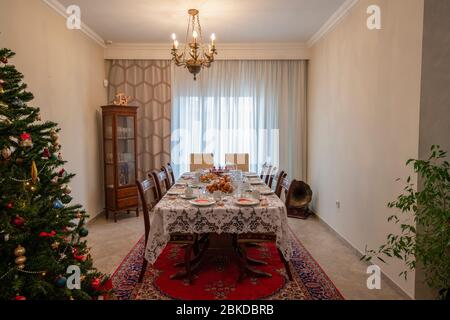Christmas table, festive Christmas table setting, elegant dishes, Christmas houses and Christmas tree Stock Photo