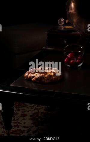 Sweet easter bread with red eggs and a gramophone on a wooden table in the living room Stock Photo