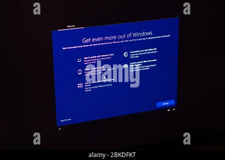 London, United Kingdom - Mar 28, 2020: Man hand POV touching the touchscreen of a modern Microsoft Windows PC computer during the update of the OS operating system Stock Photo