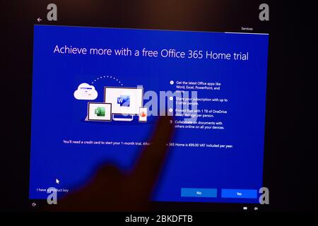 London, United Kingdom - Mar 28, 2020: Get Office 365 home trial - Man hand POV touching the touchscreen of a modern Microsoft Windows PC computer during the update of the OS operating system Stock Photo