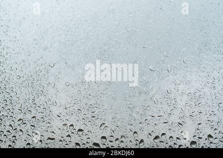 Water droplets on the window glass grey background. Selective focus. Stock Photo