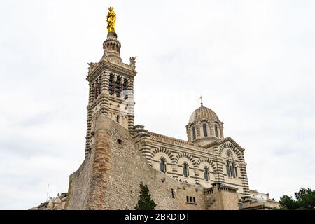 The basilica of Notre Dame de la Garde in Marseille, built in Neo-Byzantine style, At top of the bell tower there is s a golden statue of the Madonna Stock Photo
