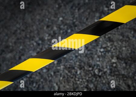 Black and yellow striped tapes on dark background. Restricted area border. Passage is forbidden. Stock Photo