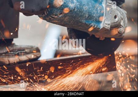 Construction worker using Angle Grinder cutting Metal at construction site . Stock Photo
