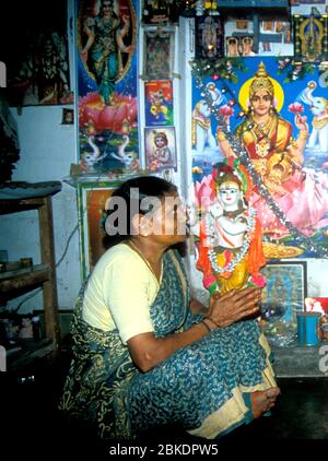 A Brahmin lady prays before the family shrine, Kerala, India Stock Photo