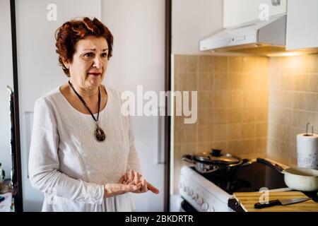 Upset senior elderly crying woman at home,hearing bad news.Coronavirus COVID-19 disease outbreak infection stress.Infected relative/friend.Lockdown so Stock Photo