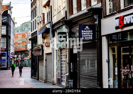 Amsterdam, Netherlands. 03rd May, 2020. A street with closed stores in kalverstraat empty and deserted during the government imposed quarantine due to the corona virus pandemic.An economic disaster recession is expected due for the closed business and shops because of the lockdown amid covid19 concerns. Credit: SOPA Images Limited/Alamy Live News Stock Photo