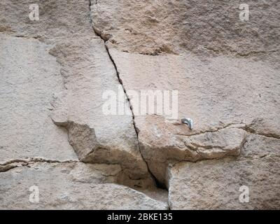 Rock climbing anchor bolt and hand or toe hold in cliff Stock Photo