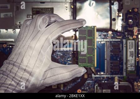 RAM Memory cards for notebook. Random access memory for replacement to laptop computer. RAM module DDR in hand on the background of a modern notebook- Stock Photo
