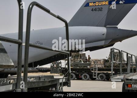 Loadmasters from the 5th Expeditionary Air Mobility Squadron and aerial porters from the 386th Expeditionary Logistics Readiness Squadron load pallets of supplies onto a C-17 Globemaster III at Ali Al Salem Air Base, Kuwait, May 2, 2020. Airmen deployed to ASAB are part of the busiest port in the U.S. Central Command theater of operations ensuring that airlift and support continue on a 24-hour operations tempo. (U.S. Air Force photo by Tech. Sgt. Alexandre Montes) Stock Photo