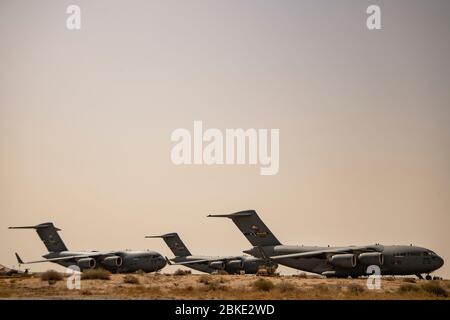 Three C-17 Globemaster III’s wait to be loaded with cargo by Airmen from the 386th Expeditionary Logistics Readiness Squadron at Ali Al Salem Air Base, Kuwait, May 2, 2020. The C-17 Globemaster III is one the most versatile and flexible airframes within the Air Force allowing Airmen in the battle area to sustain airlift support with large and heavy equipment to improve response and capabilities to U.S. and coalition forces. (U.S. Air Force photo by Tech. Sgt. Alexandre Montes) Stock Photo