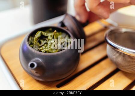 Close-up of Chinese green tea with hot water inside the small ceramic kettle for making green tea. Stock Photo