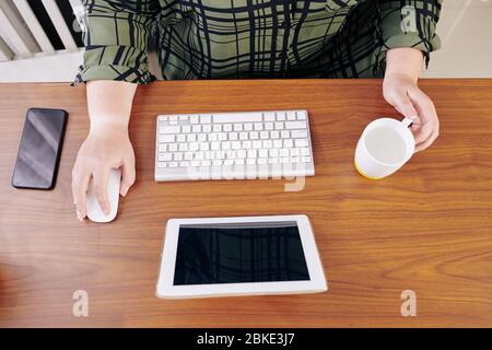 Woman drinking water when working on computer at home during lockdown, view from above Stock Photo