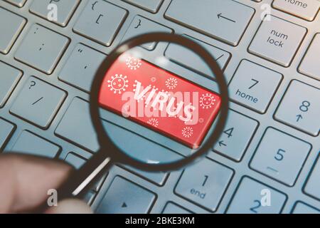 computer virus from internet, with message on enter key of keyboard. Red button with a picture of the virus and the inscription virus. Search for viru Stock Photo