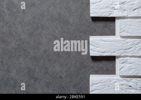 Decorative plaster brick. Texture of light beige scratched embossed brick wall with white seams and rectangular stucco bricks. Stock Photo