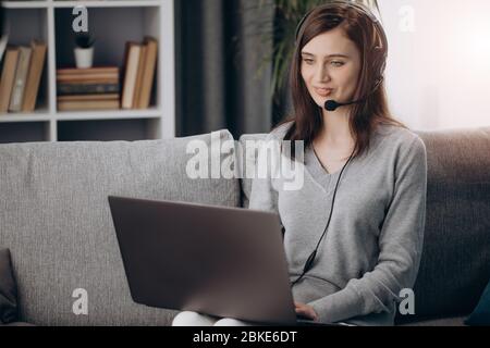 Beautiful woman in headset having video call at home Stock Photo