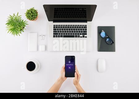 Freelancer sitting at her desk with opened laptop and using home service application, view from above Stock Photo