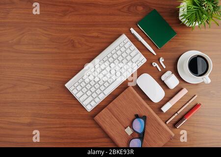 Office supplies, cup of black coffee, keyboard and digital tablet in leather cover on office desk, view from above Stock Photo