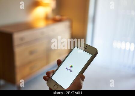 A woman using the Wayfair mobile app on her phone. Wayfair Inc. is an American e-commerce company that sells furniture and home goods. Stock Photo