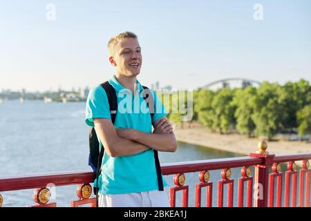 Outdoor portrait of smiling teenage boy 15, 16 years old with arms crossed Stock Photo