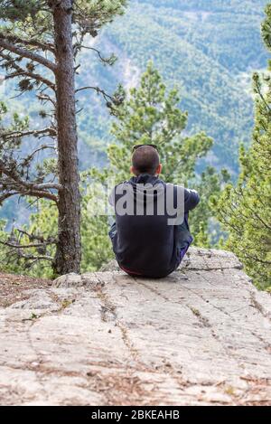 Canillo, Andorra : 2 MAY 2020 : Young man looking towards the mountains in spring in the Pyrenees of Andorra. Stock Photo