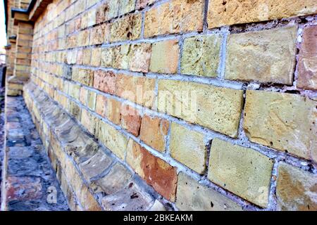 Old yellow brick wall in the old town Stock Photo