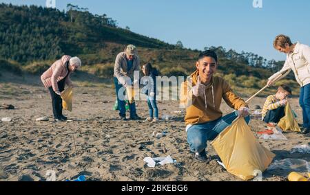 Young man cleaning the beach Stock Photo