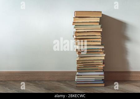 Big stack of old books over white wall, education concept, with copy space Stock Photo