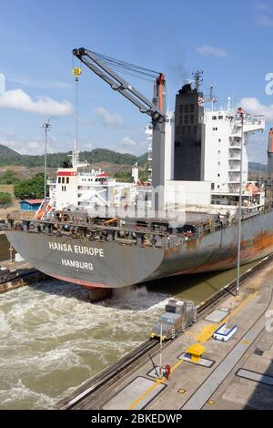 Ship with propellers running to drive out of the Miraflores lock on the panama Canal, Panama leaving a wake of churned water Stock Photo