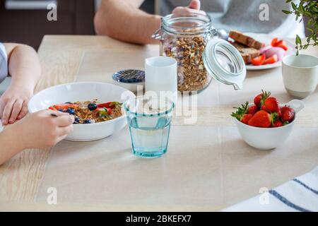 Family breakfast in the kitchen. Girl with father eat healthy breakfast. Stock Photo