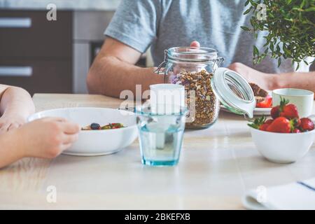 Family breakfast in the kitchen. Girl with father eat healthy breakfast. Stock Photo