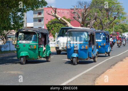 TRINCOMALEE, SRI LANKA - FEBRUARY 10, 2020: Tuk-tuks in motion on a city street on a sunny day Stock Photo