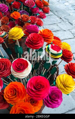 Display of multi coloured, artificial flowers for sale, Kazimierz Dolny, Poland. Wood and paper traditional handicrafts in the market square. Stock Photo