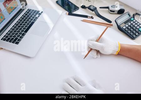 Architect working at his table and drawing blueprint on white blank sheet Stock Photo