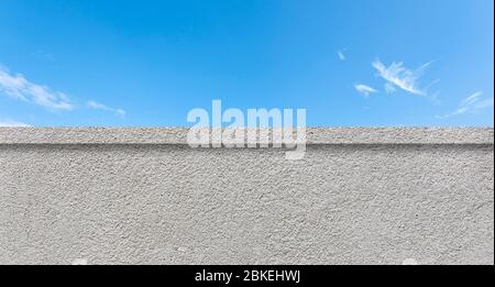 Concrete clean wall as border and blue sky with white clouds as background Stock Photo
