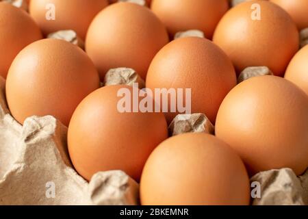 Brown egg in paper packaging. Container for eggs. Recycling. Healthy rustic breakfast Stock Photo