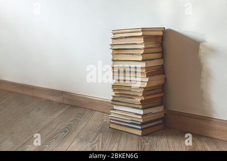 Big stack of old books over white wall, education concept, with copy space Stock Photo
