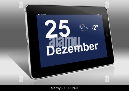 A tablet computer displays a calendar in German language with the date December 25th | Ein Tablet-Computer zeigt das Datum 25. Dezember Stock Photo