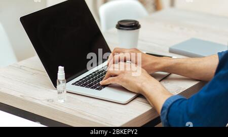 young man working on a laptop, observing security measures Stock Photo